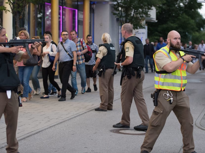 Police escort people who leave the Olympia mall in Munich, southern Germany, Friday, July 22, 2016 after shots were fired. Photo: AP