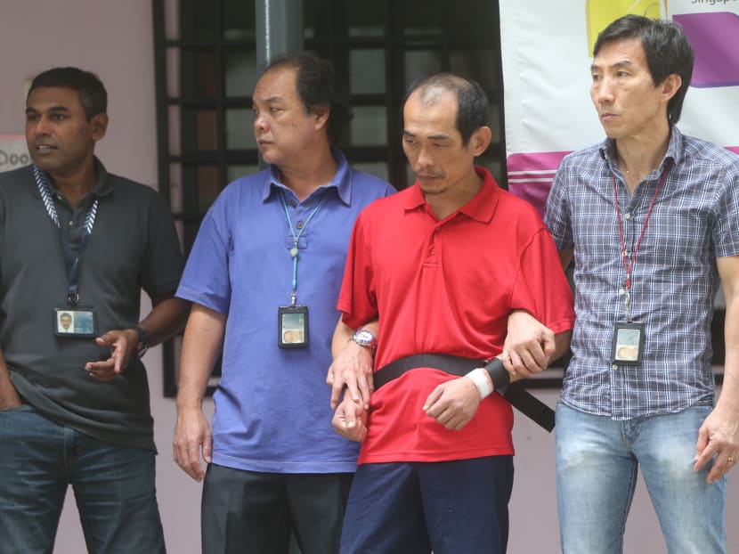 Police personnel bringing Teck Whye Lane Temple murder suspect Loh Suan Lit, 47, to Blk 15, Marsiling  Lane for a re-enactment in this file photo. TODAY file photo