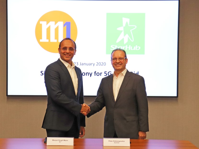 M1 chief executive officer Manjot Singh Mann (left) and StarHub CEO Peter Kaliaropoulos at the signing of their deal to bid together for a 5G network licence.