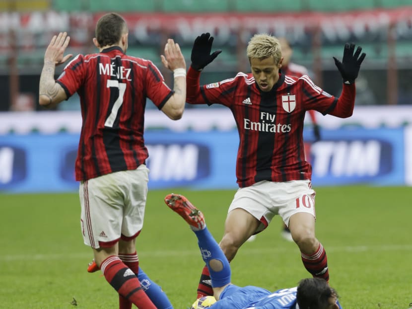 AC Milan's Keisuke Honda, right, and his teammate Jeremy Menez  challenge for the ball with Empoli’s Mario Rui Silva Duarte during a Serie A soccer match between AC Milan and Empoli, at the San Siro stadium in Milan, Italy, Sunday, Feb.15, 2015. Photo: AP