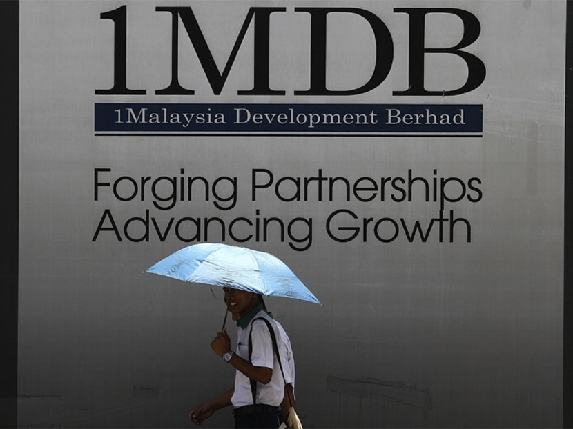A man walks past a 1MDB board. Funds from sovereign wealth fund Khazanah Nasional Berhad and Malaysia’s central bank were allegedly used by the government of former Malaysian Prime Minister Datuk Seri Najib Razak to pay the dues of state fund 1Malaysia Development Berhad (1MDB).