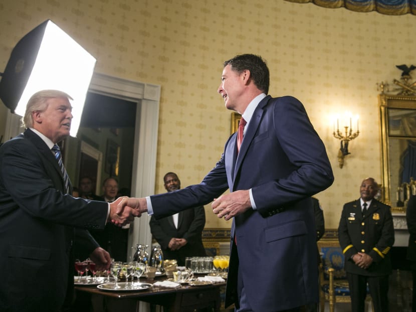 President Donald Trump and then FBI Director James Comey shake hands during a reception at the White House in Washington, Jan. 22, 2017.  Source: The New York Times