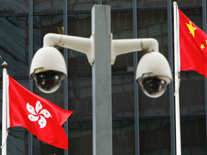 Hong Kong and Chinese flags are flown behind a pair of surveillance cameras outside the Central Government Offices in Hong Kong.