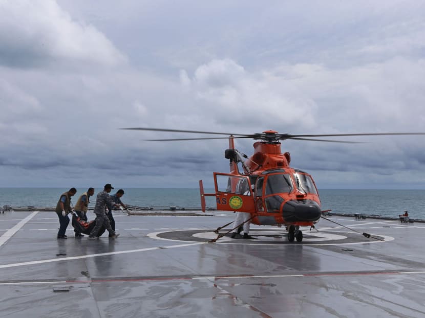 Military personnel load a bodybag containing what is believed to be a victim of AirAsia QZ 8501 onto a helicopter on the deck of Indonesian Navy ship KRI Banda Aceh in the Java Sea. Photo: AP