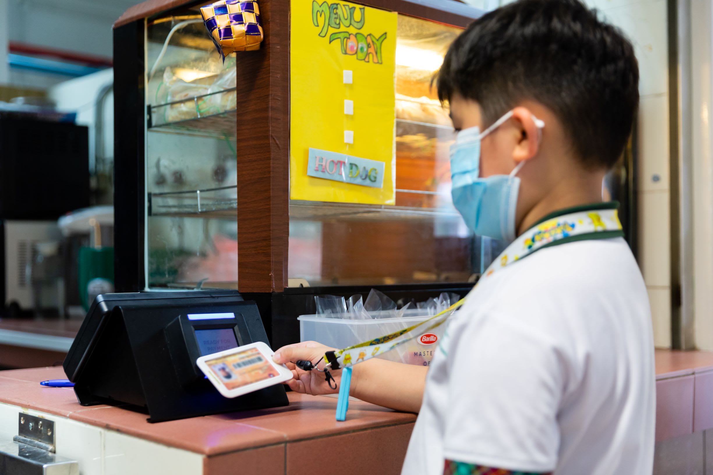 A student making a purchase at a POSB Smart Buddy tap-and-pay terminal at Xishan Primary School's canteen. A student making a purchase at a POSB Smart Buddy tap-and-pay terminal at Xishan Primary School's canteen.