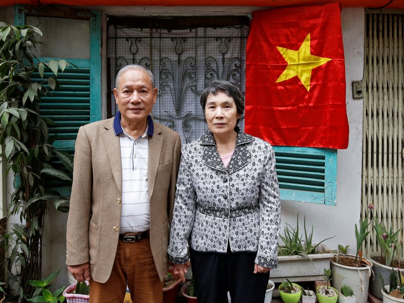 Former Vietnamese chemical student Pham Ngoc Canh who studied in North Korea and his North Korean wife Ri Yong Hui stand in front of their house while posing for a photo in Hanoi, Vietnam.