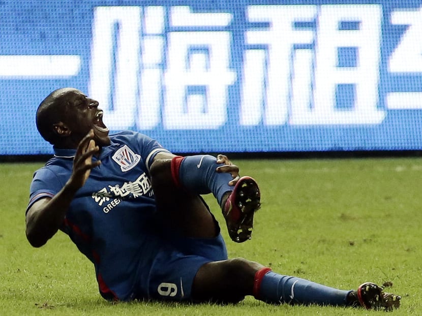 Demba Ba writhing in pain after breaking his leg. Photo: AFP