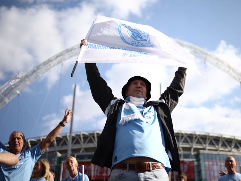 Manchester City fans celebrate as they leave Wembley Stadium in London after the FA Cup final football match between Manchester City and Manchester United on June 3, 2023.