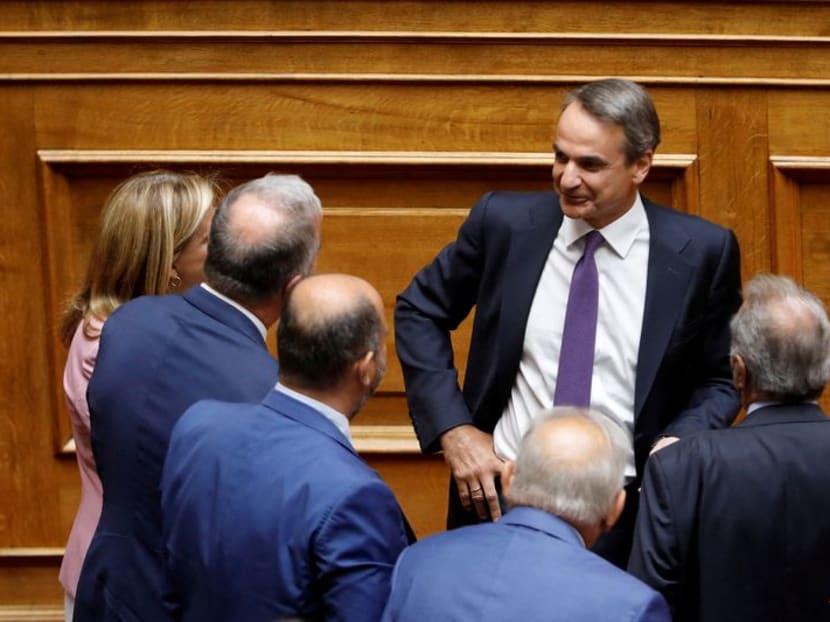 FILE PHOTO: Greek Prime Minister Kyriakos Mitsotakis speaks with members of his government and lawmakers during a parliamentary session on a wiretapping case, in Athens, Greece, August 26, 2022. REUTERS/Costas Baltas/File Photo