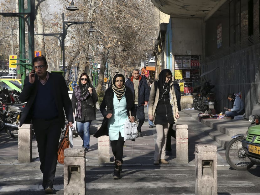 Pedestrians cross a street in central Tehran. Photo: AP