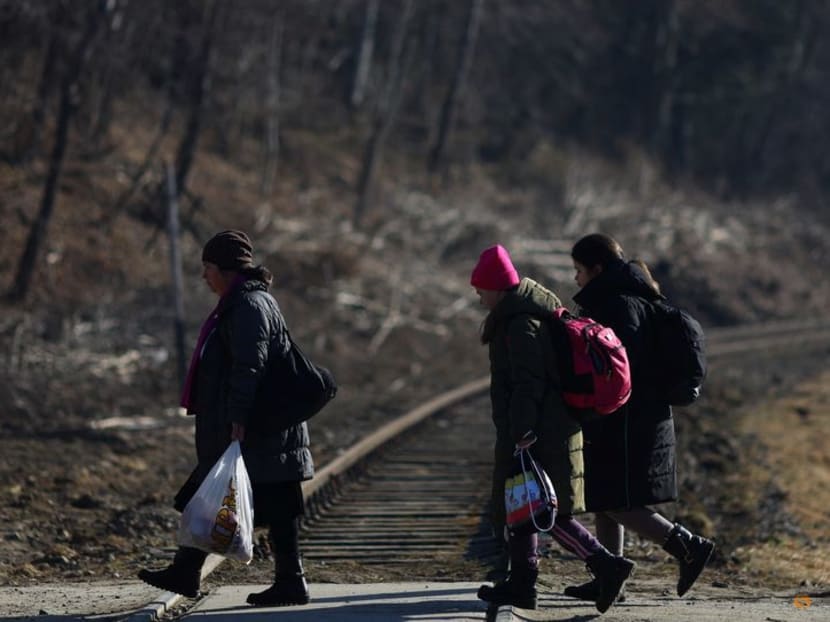 Ukrainian refugees fleeing Russia's invasion of Ukraine, walk after crossing the border between Ukraine and Poland, in Kroscienko, Poland, March 22, 2022.REUTERS/Hannah McKay