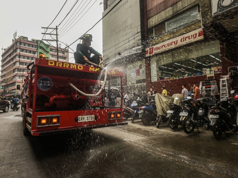 Firemen spray disinfectant to prevent the spread of the Covid-19 coronavirus, at a market in Manila on March 11, 2020.