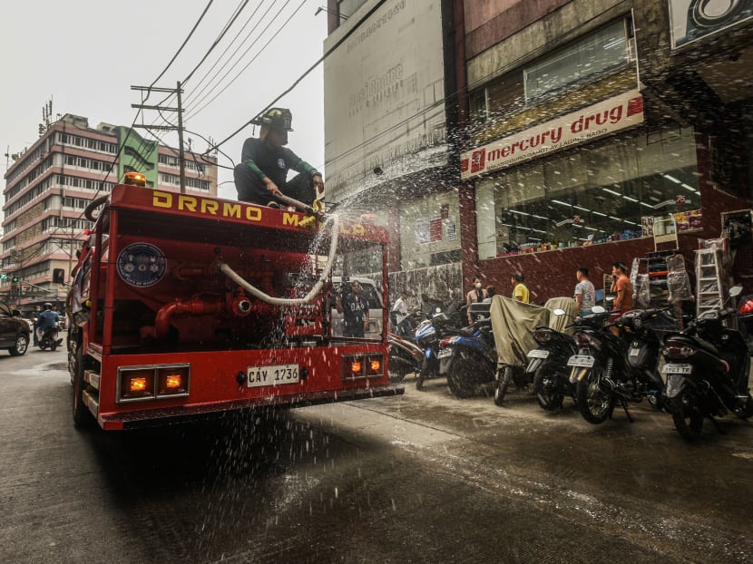 Firemen spray disinfectant to prevent the spread of the Covid-19 coronavirus, at a market in Manila on March 11, 2020. Firemen spray disinfectant to prevent the spread of the Covid-19 coronavirus, at a market in Manila on March 11, 2020.