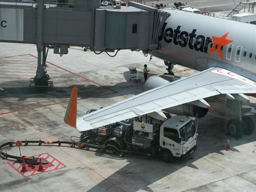 A refuelling truck is parked next to a Jetstar plane at Changi International Airport in Singapore on May 13, 2022.