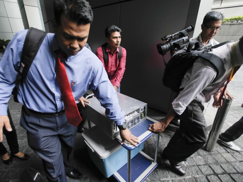 Malaysian plainclothes police cart away a computer from the 1MDB office after a raid in Kuala Lumpur. Photo: AP