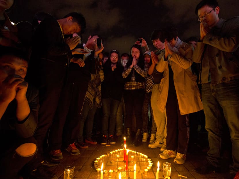 People praying for the massacre victims yesterday outside the Kunming Railway Station, where more than 10 assailants slashed scores of people with knives on Saturday night in western China's Yunnan province. Photo: AP