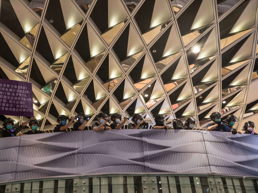 Riot police raise a warning flag in a shopping mall after protesters gathered at the nearby Yuen Long train station in Hong Kong on July 21, 2020. Riot police raise a warning flag in a shopping mall after protesters gathered at the nearby Yuen Long train station in Hong Kong on July 21, 2020.
