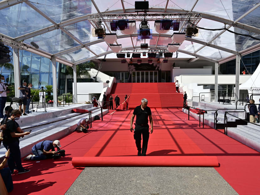 Festival staff roll the red carpet as the 74th edition of the Cannes Film Festival kicks off in southern France on July 6, 2021.