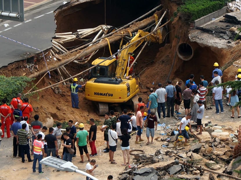 Rescuers searching for missing people after a giant sinkhole opened up on a road in Zhengzhou, in central China's Henan province. Photo: AFP