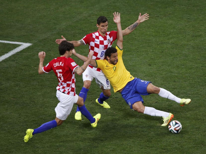 Fred (right) dropped like a bag of lead under a feather challenge from Croatia’s Dejan Lovren (centre). Photo: REUTERS