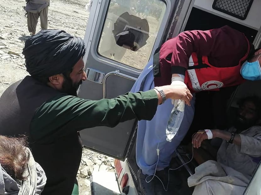 A member of the Afghan Red Crescent Society giving medical treatment to a victim following an earthquake in Afghanistan's Gayan district, Paktika province.