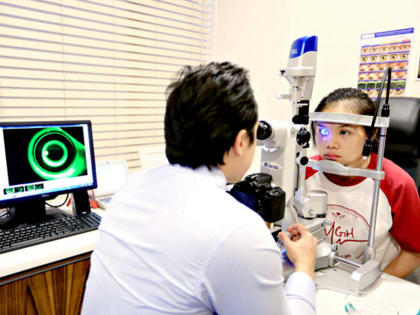 Ortho-k lens user Goh Jia Ling (right) having her cornea checked by orthokeratologist Titus Wu during a review session. Photo: Koh Mui Fong
