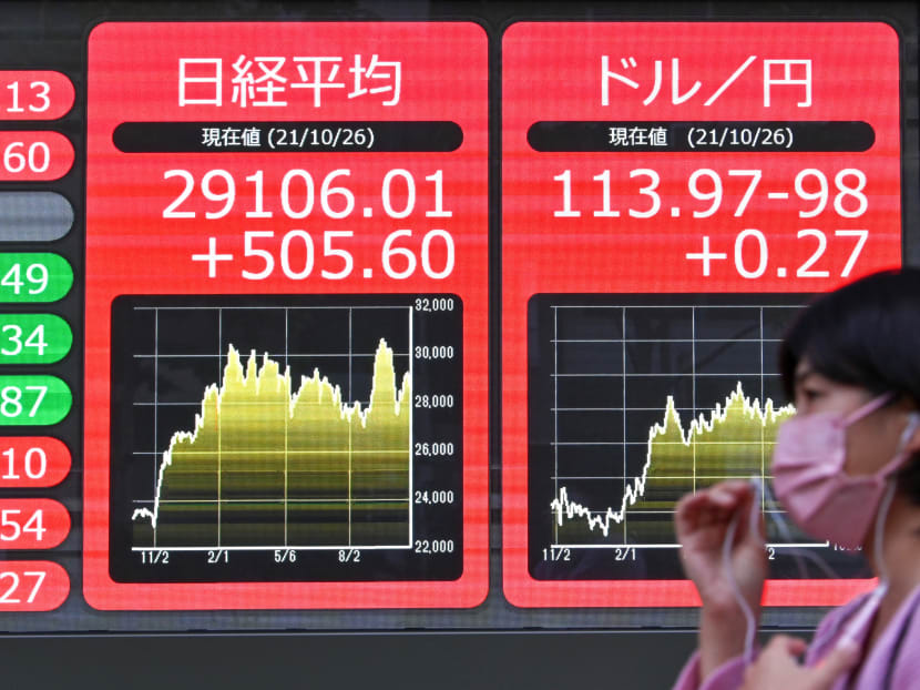An electronic stock market board in Tokyo on Oct 26, 2021. The flare-up of uncertainty over the new Covid variant sent safe-haven currencies up with the yen — a go-to unit in times of turmoil — piling ahead against the dollar.