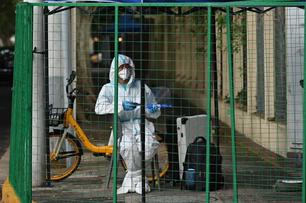 A worker is seen behind fencing in a closed-off neighborhood in a residential area under a Covid-19 lockdown in the Huangpu district of Shanghai on June 4, 2022. A worker is seen behind fencing in a closed-off neighborhood in a residential area under a Covid-19 lockdown in the Huangpu district of Shanghai on June 4, 2022.