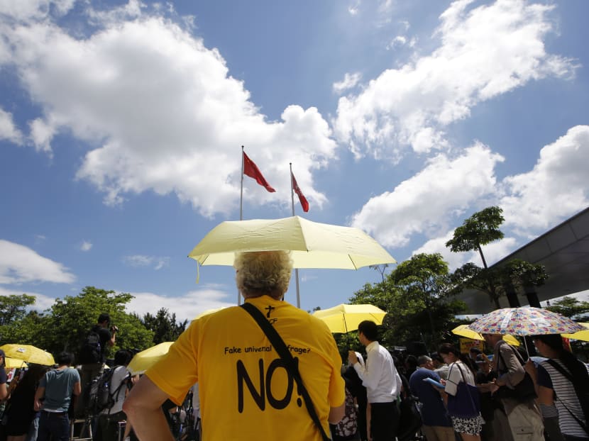 A pro-democracy protester holding a yellow umbrella attends a rally outside the Legislative Council in Hong Kong, June 17, 2015. Photo: AP