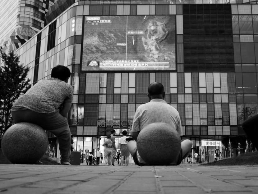 People watching a news broadcast on the South China Sea outside a shopping mall in Beijing. The path towards resolving the South China Sea disputes is fraught with challenges. Photo: Reuters