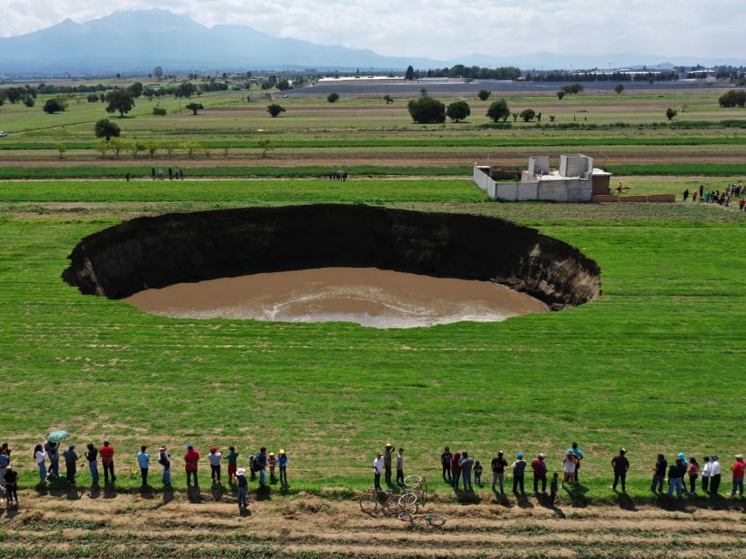Aerial view of a sinkhole that was found by farmers in a field of crops in Santa Maria Zacatepec, state of Puebla, Mexico on May 30, 2021.