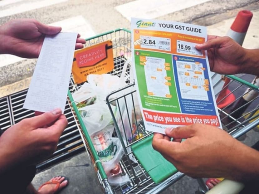 Shoppers check if they are being charged GST correctly. Consumer groups and activists say the big number of complaints following the implementation of the tax shows consumerism is alive and well. Photo: Malay Mail Online