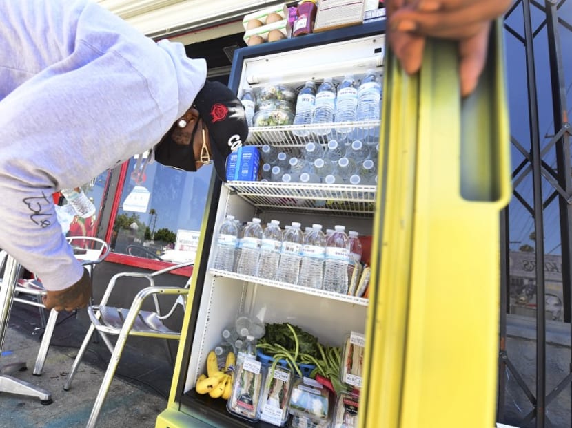 Mr Danny Dierich stocks a community refrigerator with more items outside the Little Amsterdam Coffee shop in Los Angeles, California, July 16, 2020.