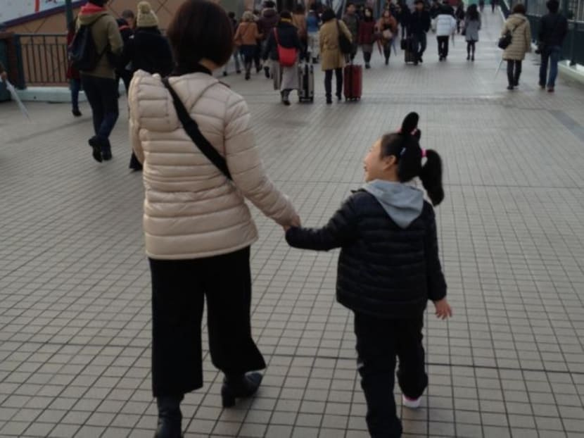 Mari Takada (L), a single mother by choice and representative of a group which provides information and support to single mothers, walks with her child in this undated photo. Photo: Mari Takada via Kyodo