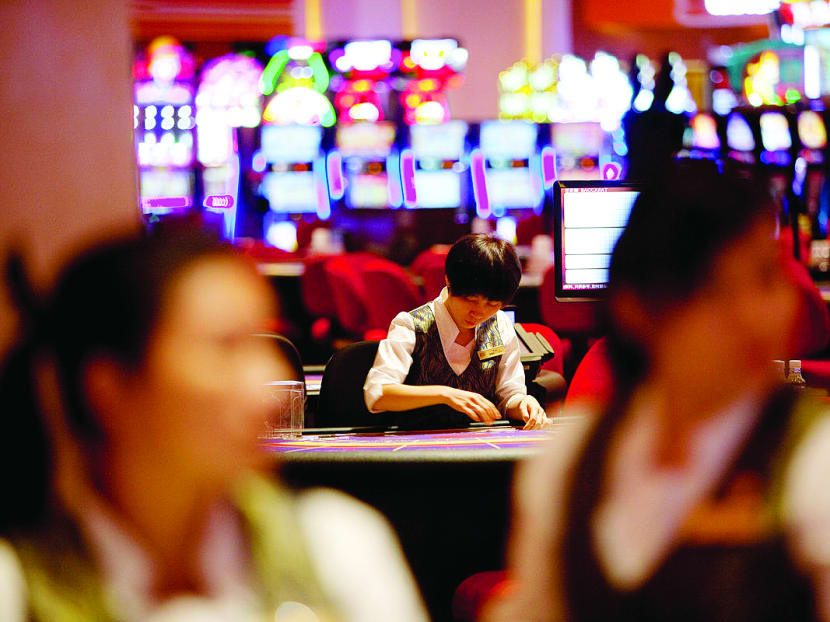 Croupiers stand at card tables in the Sands Cotai Central casino resort in Macau, China. Photo: Bloomberg