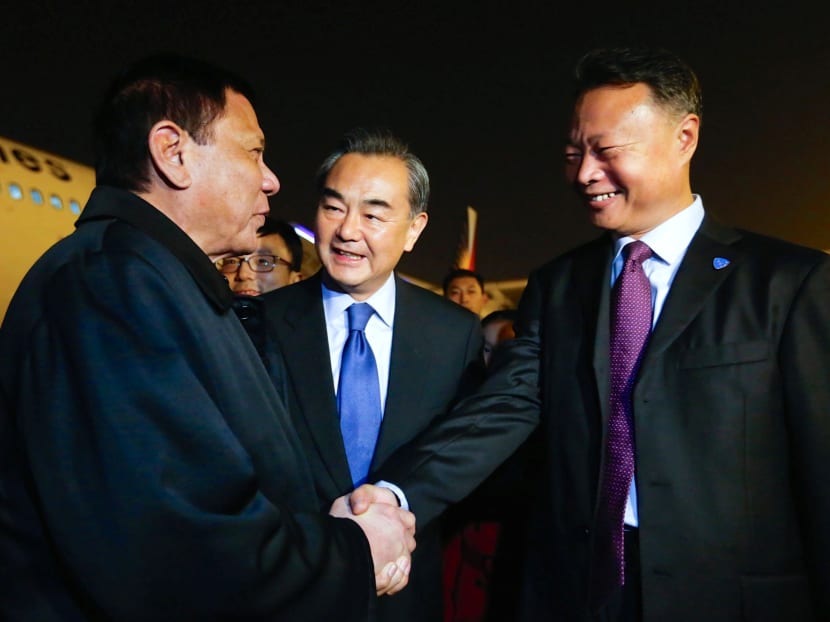 President of the Philippines Rodrigo Duterte shakes hands with Chinese ambassador to the Philippines Zhao Jianhua, as Chinese Foreign Minister Wang Yi looks on, at the airport in Beijing, China, October 18, 2016. Photo: CNS via Reuters