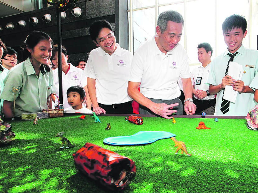 Prime Minister Lee Hsien Loong playing Marbles: Jurassic Park with students from Yio Chu Kang Secondary after launching the Singapore HeritageFest 2013 yesterday. Photo: Ooi Boon Keong