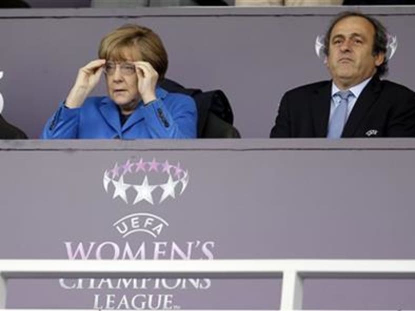German Chancellor Angela Merkel, left, and UEFA President Michel Platini, right, attend the Women's Champions League Final soccer match between 1 FFC Frankfurt and Paris Saint-Germain in Berlin, Germany, on May 14, 2015. Photo: AP