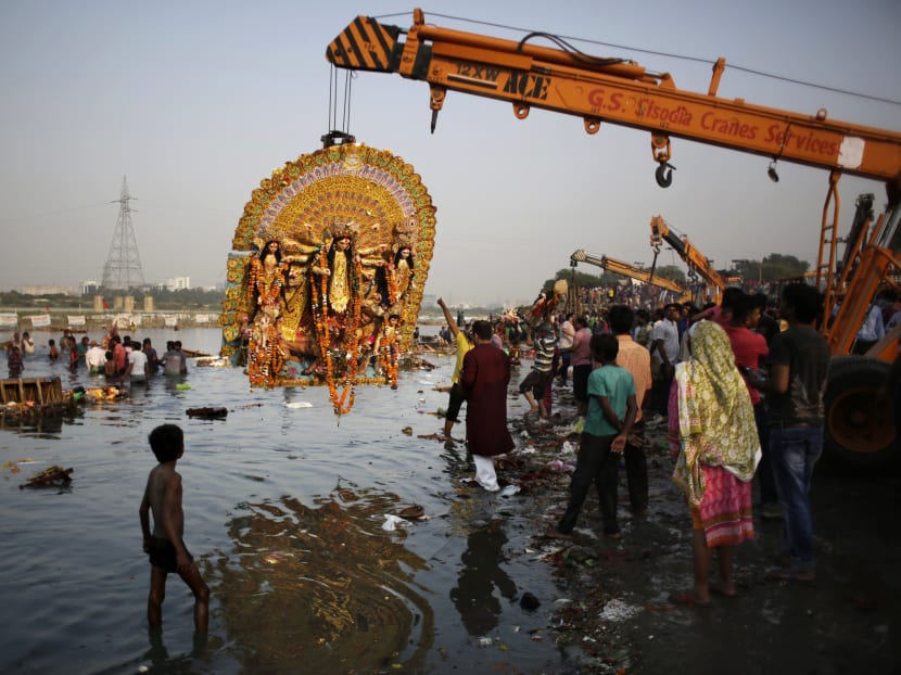 File photo of a giant idol of Hindu goddess Durga suspended from a crane before it was immersed in the River Yamuna during Durga Puja festival in New Delhi, India on Oct 11, 2016. Photo: AP