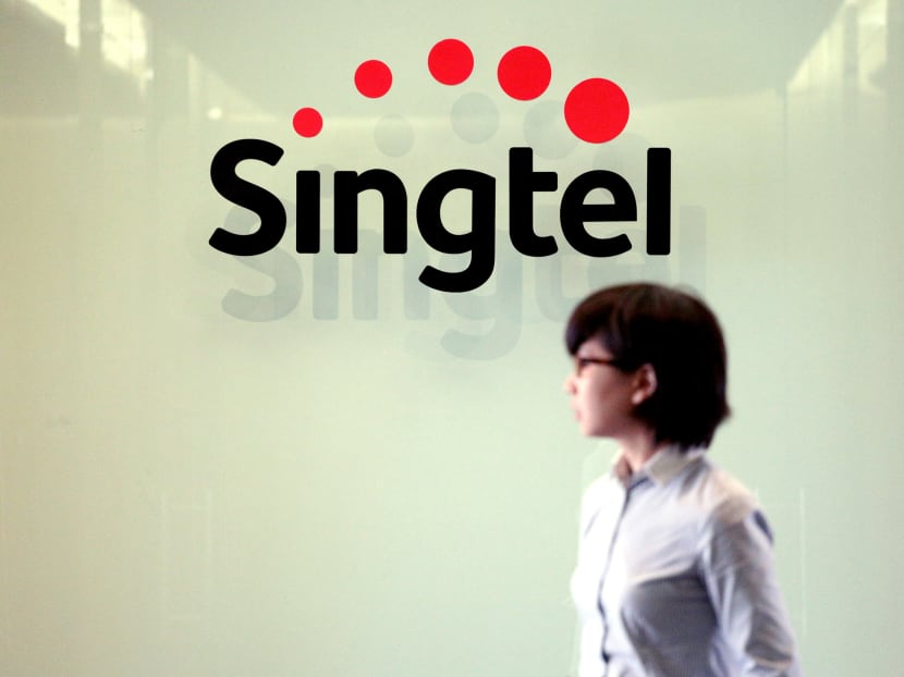 A woman walks past a Singtel logo at the Singtel comcentre. TODAY file photo