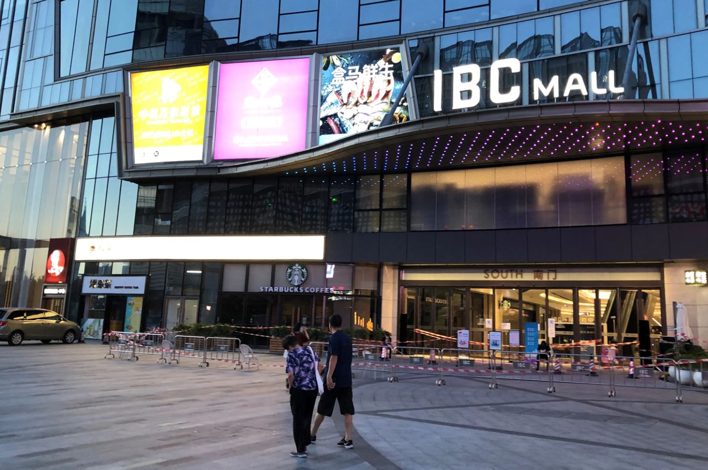 People wearing face masks walk past Shenzhen's IBC Mall, which has been sealed off after a new case of the coronavirus disease (COVID-19) was confirmed, Guangdong, China on Aug 14, 2020. 