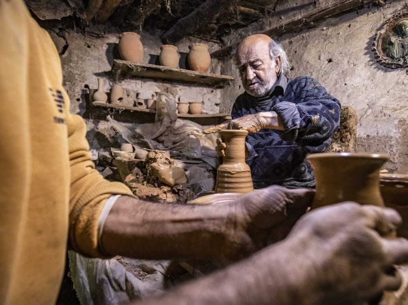 Syrian-Armenian potter Misak Antranik Petros uses an ancient pottery wheel to churn different types of pots at his workshop located inside an ancient mud-brick house near the city of Qamishli in Syria's northeastern Hasakeh province on Dec 19, 2020.