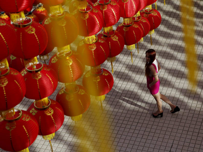 A woman walks under chinese lanterns ahead of Chinese New Year celebrations at a temple in Kuala Lumpur, Malaysia on Feb 1, 2016.