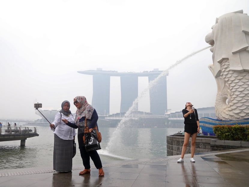 Tourists at Merlion Park on Sept 16. The haze continues to enshroud Singapore, as the F1 Singapore Grand Prix approaches. Photo: Ooi Boon Keong/TODAY