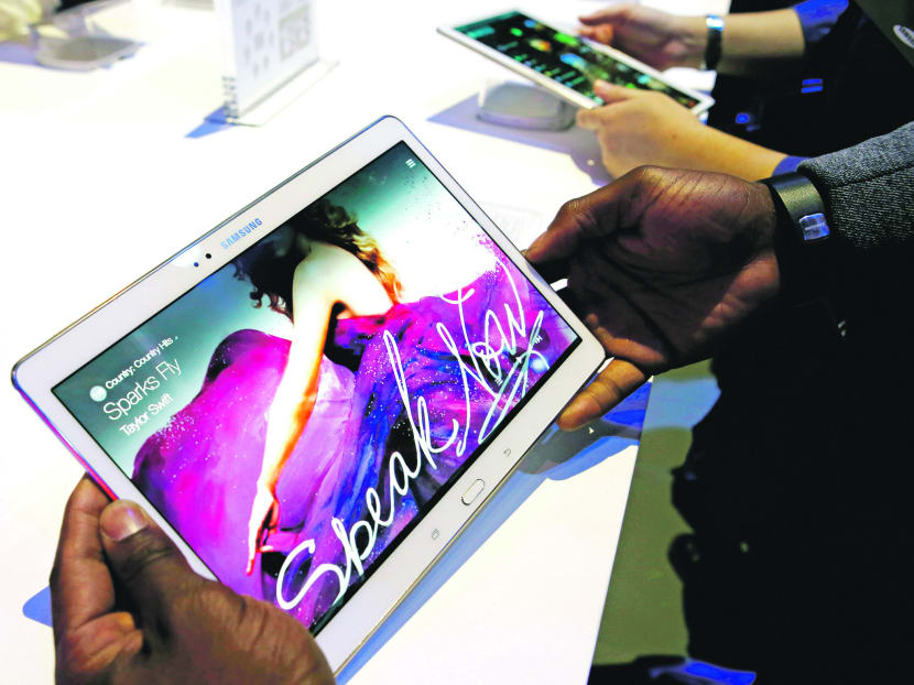 Members of the media try out samples of the Samsung Galaxy Tab S after the tablet was debuted at a press conference in New York, Thursday, June 12, 2014. The new Samsung tablets feature screens that are richer in color than standard LCDs.  The screens, known as AMOLED, for active-matrix organic light-emitting diodes, are already found in smartphones made by Samsung and a few other manufacturers. But until now, tablets haven’t used them because larger AMOLED screens are more difficult to produce. (AP Photo/Kathy Willens)