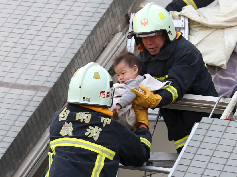 Rescue workers remove a baby from the site where a 17-storey apartment building collapsed after an earthquake hit Tainan, Feb 6, 2016. Photo: Reuters