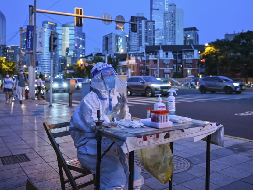 A health worker waits to test people for the Covid-19 coronavirus on a street next to a residential area in the Jing'an district of Shanghai on July 5, 2022.<br />
&nbsp;