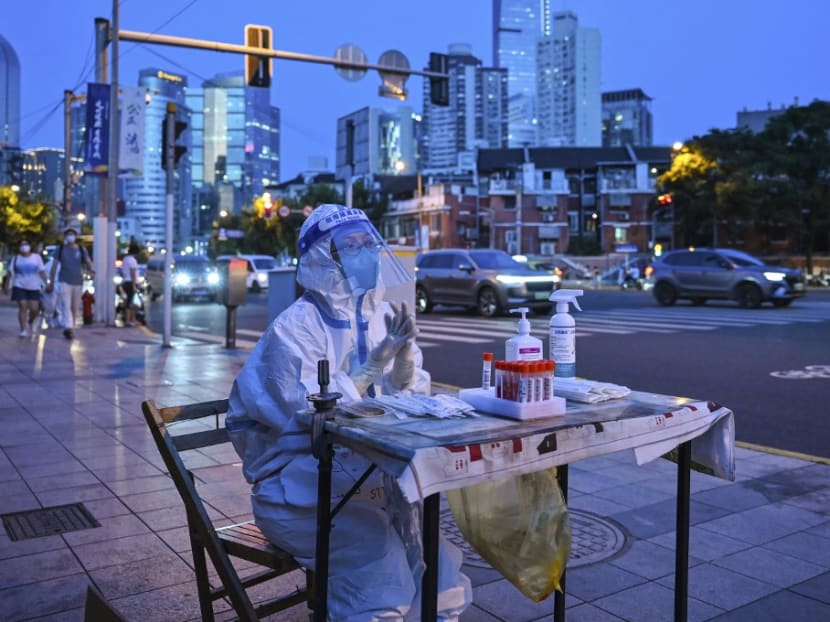 A health worker waits to test people for the Covid-19 coronavirus on a street next to a residential area in the Jing'an district of Shanghai on July 5, 2022.<br />
A health worker waits to test people for the Covid-19 coronavirus on a street next to a residential area in the Jing'an district of Shanghai on July 5, 2022.<br />

