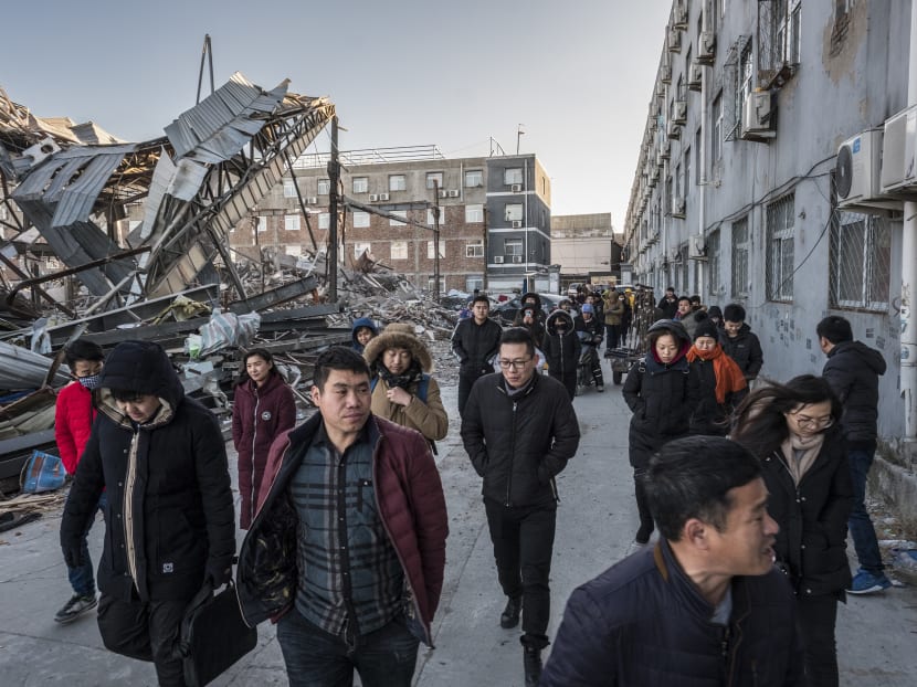Residents of an apartment block who were given just 48 hours to vacate, walk en masse to the local government office to demand that their rent be reimbursed, in southern Beijing. Photo: NYT