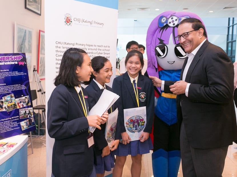 Communications and Information Minister S Iswaran (far right) interacting with student exhibitors from CHIJ (Katong) Primary School at the Better Internet Conference 2019.